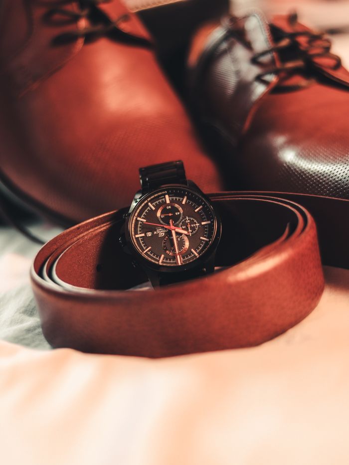 about-us-02 Stylish close-up of brown leather shoes, belt, and wristwatch for fashion-forward men.